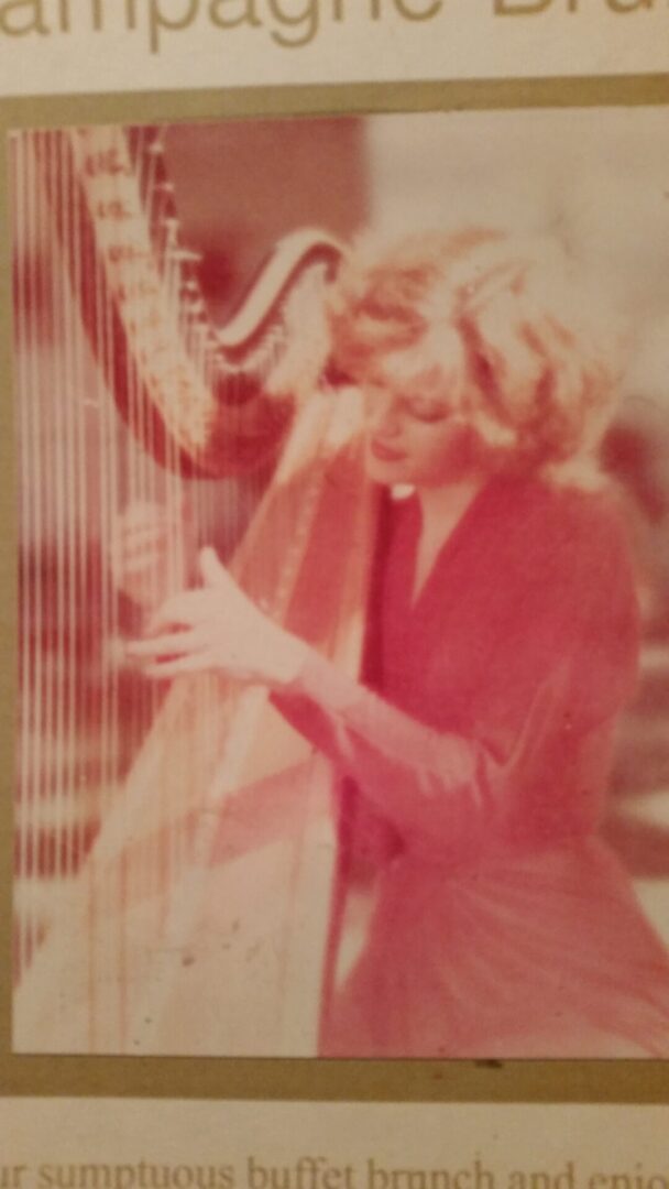 A picture of a woman playing a harp